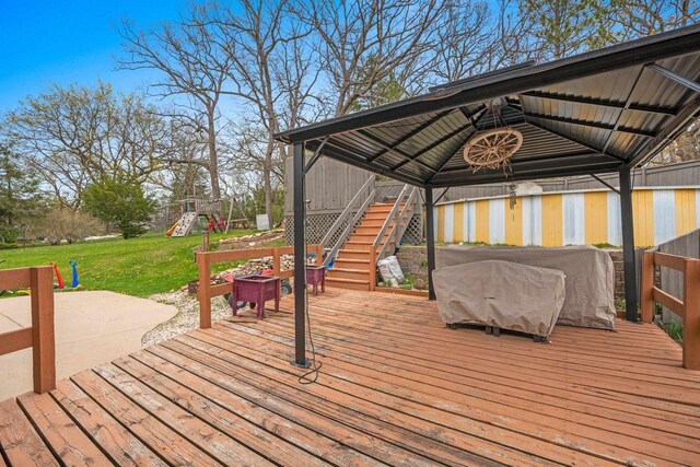 deck featuring a yard, a gazebo, stairway, and a playground