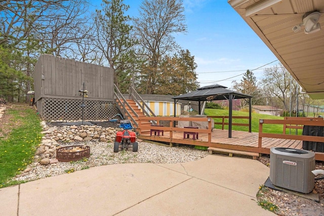 view of patio featuring a gazebo, a wooden deck, stairway, central air condition unit, and a fire pit