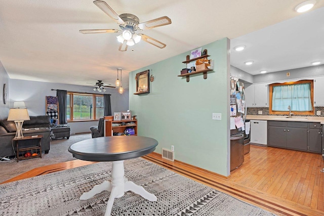 dining area with visible vents, a ceiling fan, and light wood-style flooring