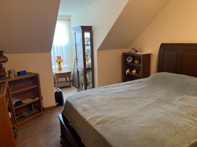 carpeted bedroom featuring lofted ceiling