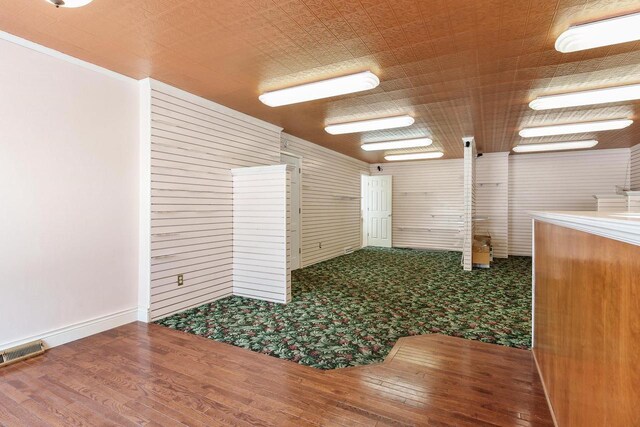 unfurnished room featuring baseboards, visible vents, and wood finished floors