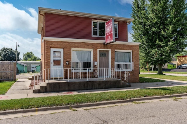 view of front of home with a porch and brick siding