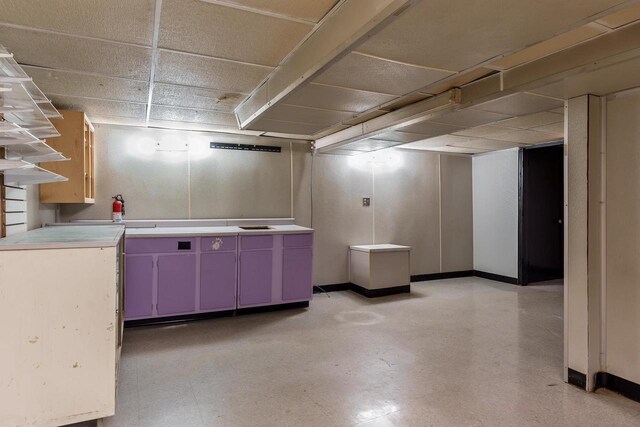 finished below grade area featuring baseboards and a drop ceiling