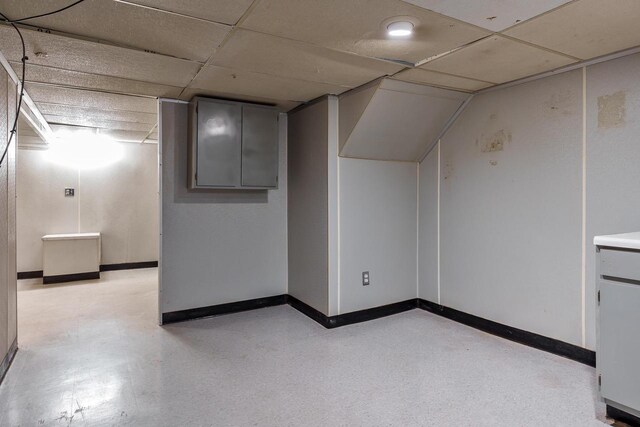 interior space with baseboards and a paneled ceiling