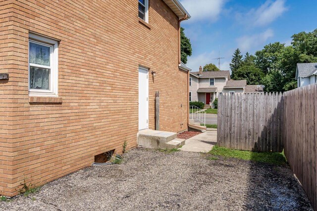 view of home's exterior featuring fence and brick siding
