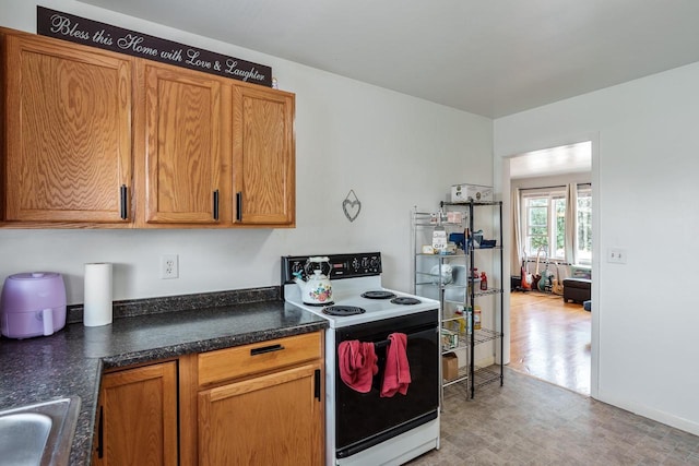 kitchen with brown cabinetry, a sink, and electric range oven