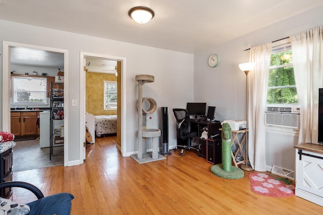office space featuring cooling unit, baseboards, visible vents, and light wood-type flooring