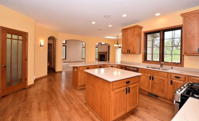 765 Safer Ct, Brookfield, WI 53045 - kitchen with a sink, a peninsula, black range with gas stovetop, arched walkways, and stainless steel dishwasher