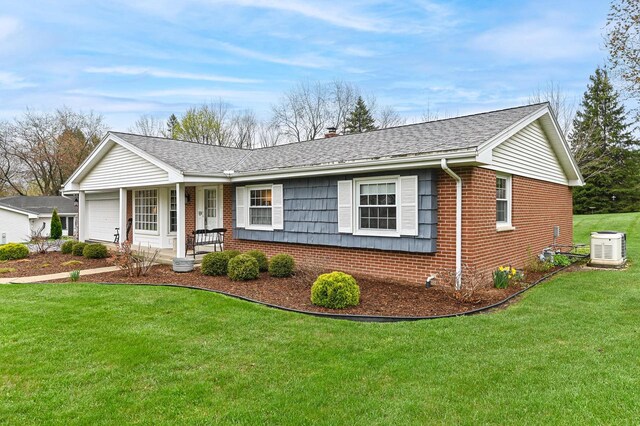 ranch-style home featuring roof with shingles, an attached garage, a front lawn, and brick siding
