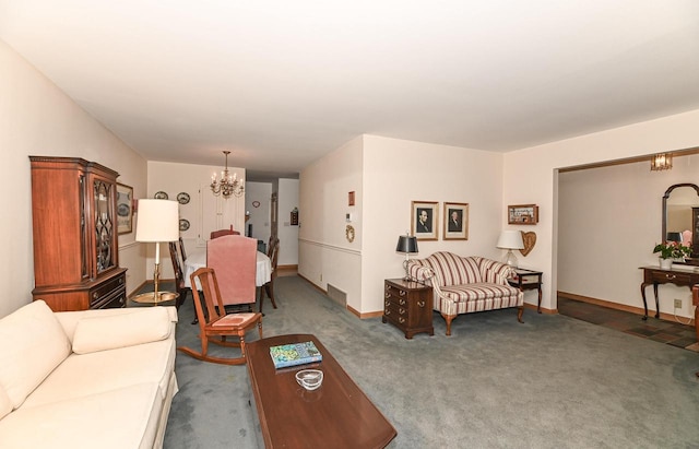 living room featuring carpet floors, baseboards, and a chandelier