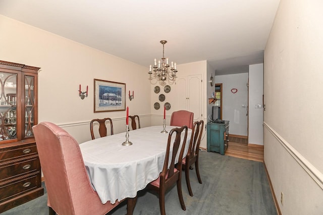 dining room featuring carpet flooring and a chandelier