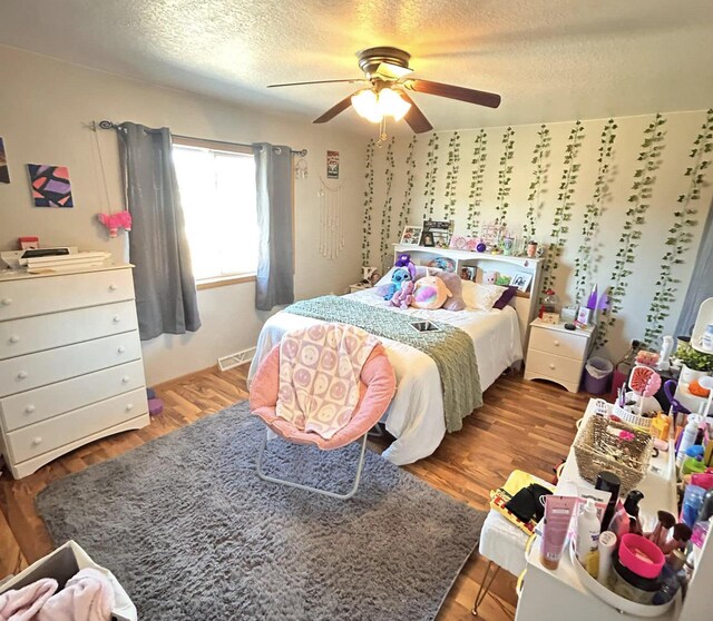 2193 Julie Ave, Sparta, WI 54656 - bedroom with visible vents, a ceiling fan, a textured ceiling, and wood finished floors