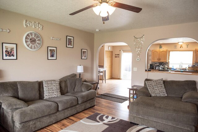 2193 Julie Ave, Sparta, WI 54656 - living room featuring arched walkways, ceiling fan, wood finished floors, and a textured ceiling