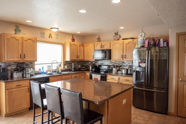 2193 Julie Ave, Sparta, WI 54656 - kitchen with a textured ceiling, tasteful backsplash, a sink, black appliances, and light tile patterned flooring