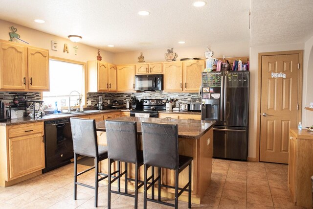 2193 Julie Ave, Sparta, WI 54656 - kitchen featuring a center island, a sink, light brown cabinetry, and black appliances