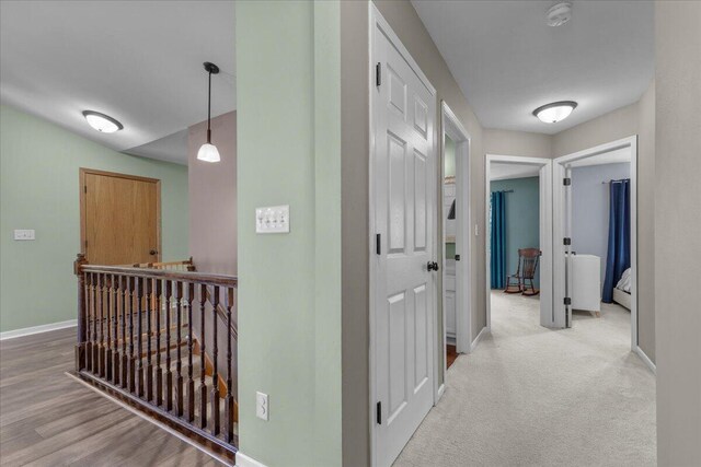 hallway featuring baseboards and an upstairs landing