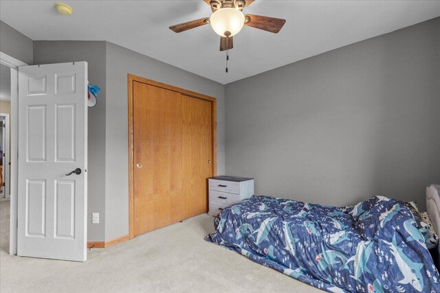 bedroom with baseboards, ceiling fan, carpet, and a closet