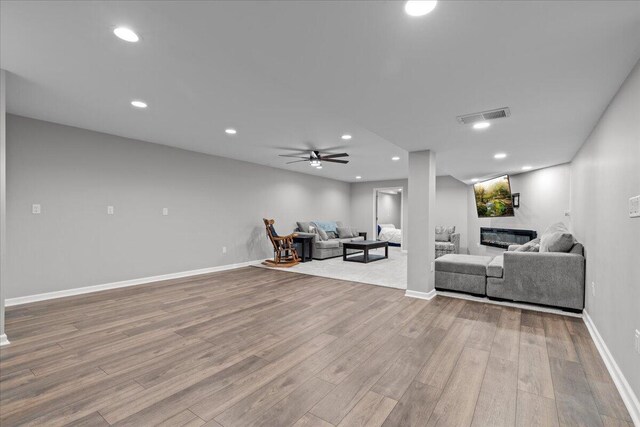 living room with visible vents, recessed lighting, baseboards, and wood finished floors