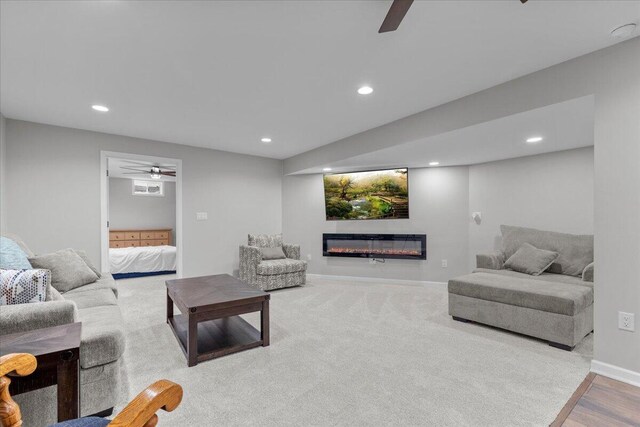 living area featuring recessed lighting, ceiling fan, and a glass covered fireplace