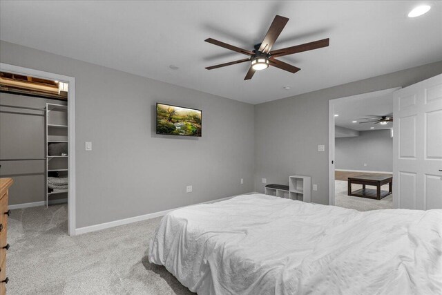 bedroom featuring light colored carpet, baseboards, a closet, a spacious closet, and recessed lighting