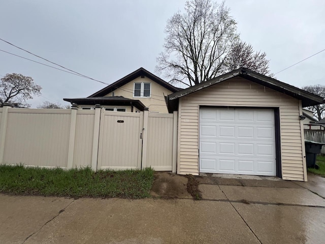 garage with fence and driveway