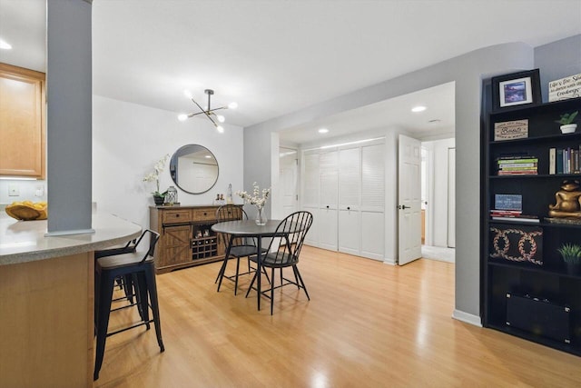 dining space with recessed lighting, an inviting chandelier, and light wood-style floors