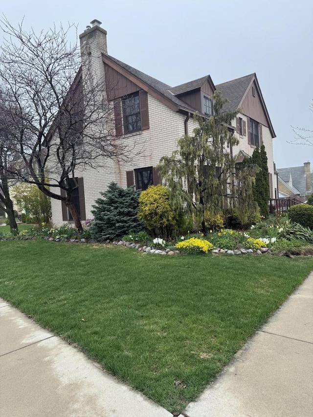 3216 Moorland Ave, Racine, WI 53405 - view of side of property featuring a lawn, brick siding, board and batten siding, and a chimney