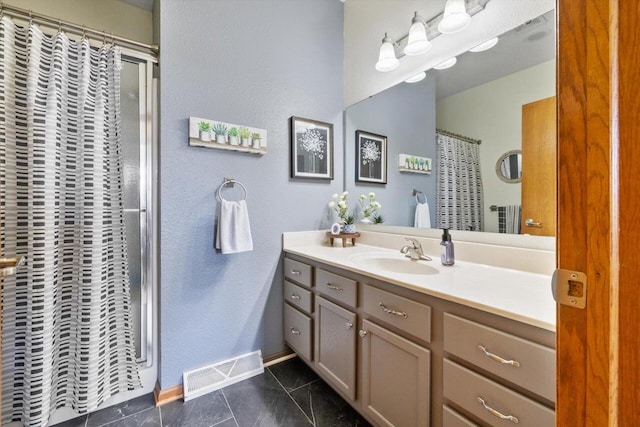 full bathroom with baseboards, visible vents, a shower with shower curtain, and vanity