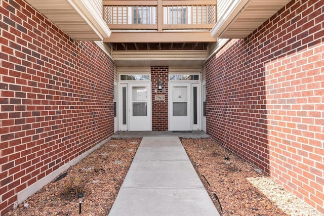 entrance to property featuring brick siding and a balcony