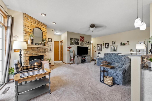 carpeted living area featuring a ceiling fan, visible vents, and a fireplace