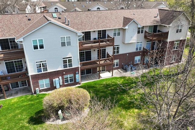 exterior space with brick siding, a lawn, and a residential view