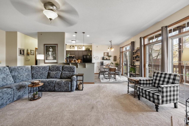 living area with a ceiling fan and light carpet