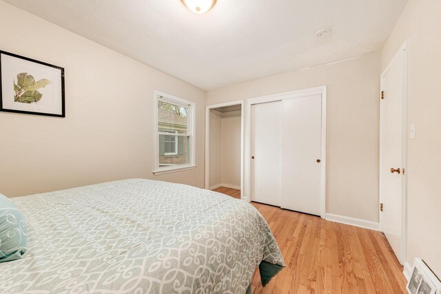 bedroom with baseboards, visible vents, and light wood-style flooring
