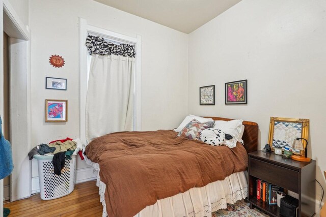 bedroom with baseboards and wood finished floors