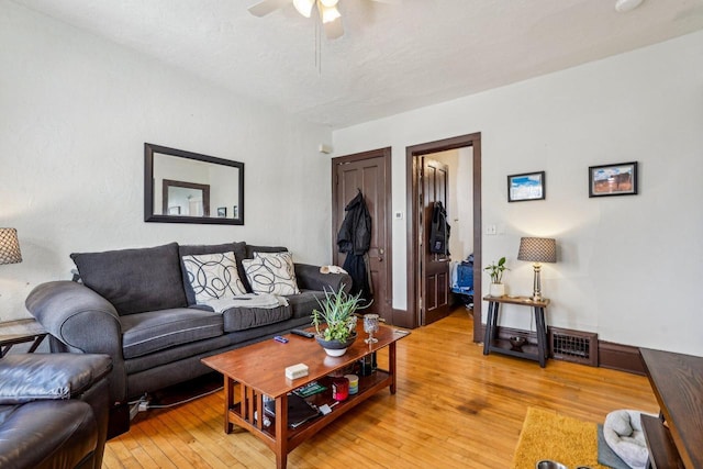 living room featuring light wood-style floors, ceiling fan, and visible vents