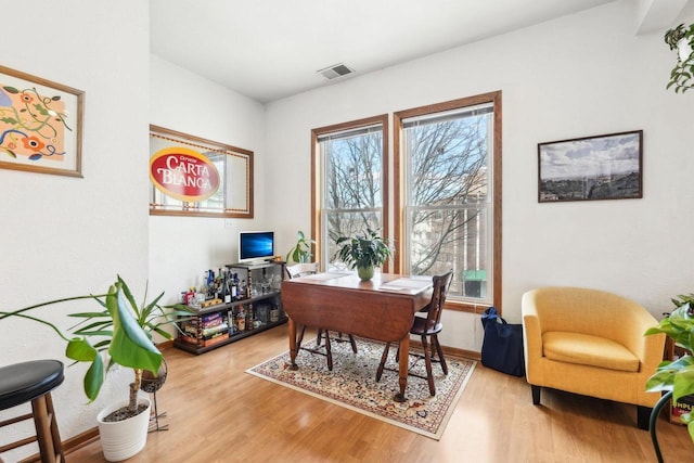 home office featuring baseboards, wood finished floors, and visible vents