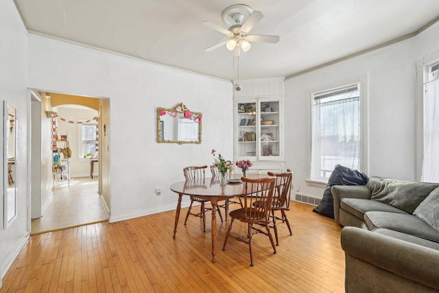 dining room featuring a healthy amount of sunlight, a ceiling fan, visible vents, built in features, and light wood finished floors