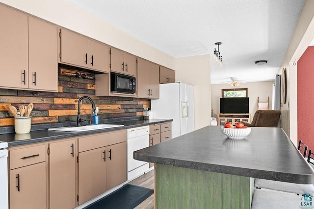kitchen with decorative backsplash, a ceiling fan, dark countertops, a sink, and white appliances