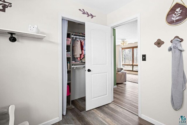 bedroom with a closet, baseboards, and wood finished floors