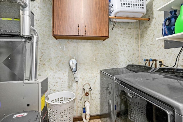 clothes washing area featuring washer and clothes dryer and cabinet space