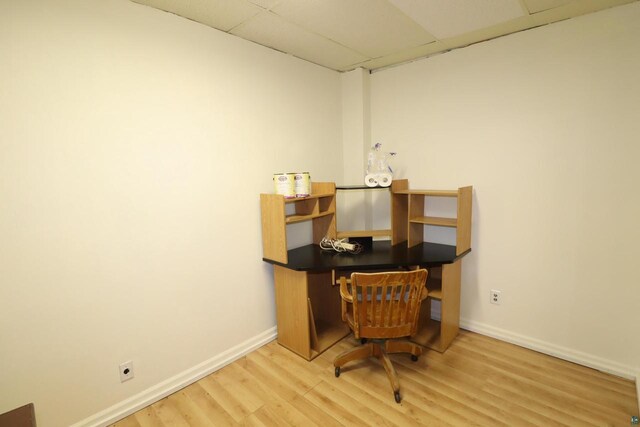 office area with baseboards, a drop ceiling, and wood finished floors