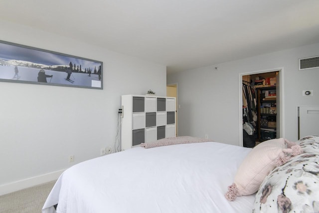 bedroom featuring a walk in closet, visible vents, baseboards, a closet, and carpet