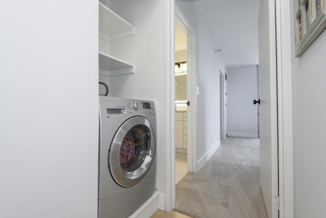 washroom featuring laundry area, baseboards, washer / clothes dryer, and light carpet