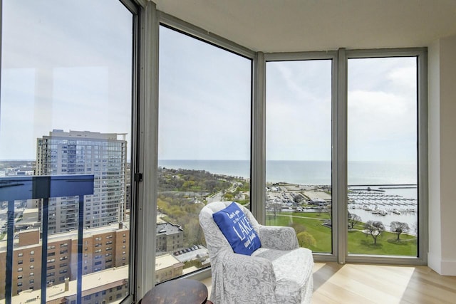 sunroom / solarium with a water view, a city view, and a wealth of natural light