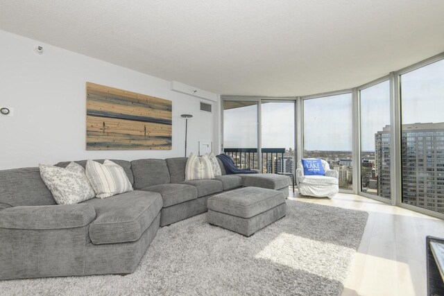 living room featuring floor to ceiling windows and visible vents