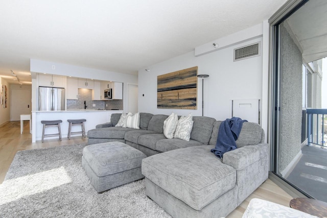 living room with visible vents and light wood-type flooring