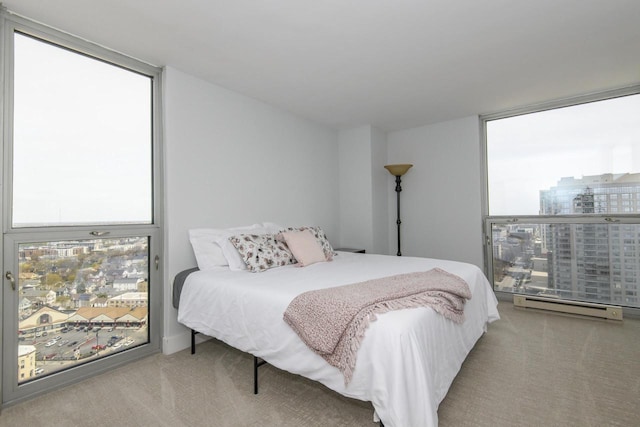 carpeted bedroom featuring a baseboard radiator, floor to ceiling windows, and multiple windows