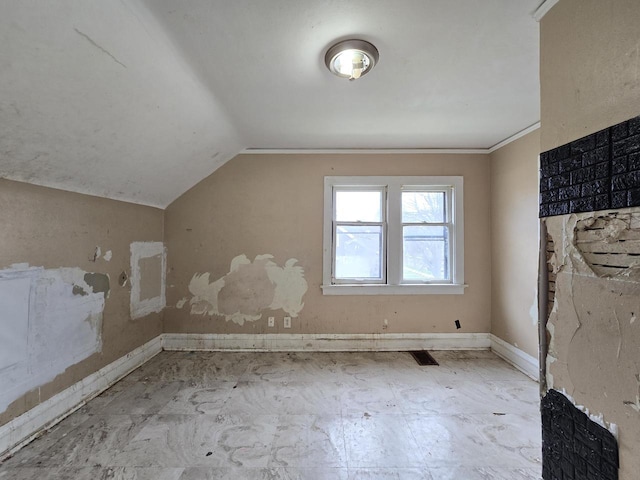 additional living space with baseboards, vaulted ceiling, and visible vents