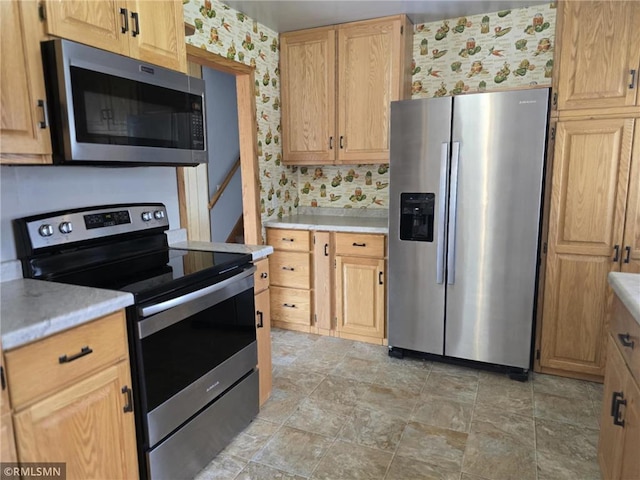 439 270th Ave, Cumberland, WI 54829 - kitchen featuring light brown cabinetry, stone finish floor, wallpapered walls, light countertops, and appliances with stainless steel finishes