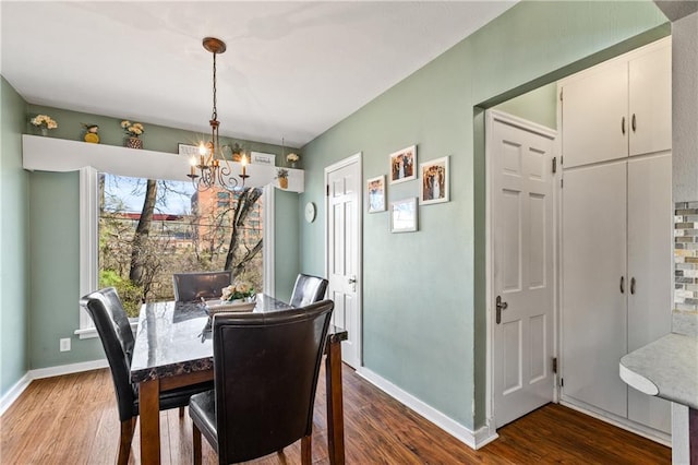 dining area with baseboards, a chandelier, and dark wood-style floors
